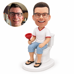 custom bobblehead figure fully clothed man in cropped trousers seated on a toilet holding a plunger