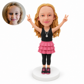 custom bobblehead figure girl in a ruffled skirt and leggings with both arms raised
