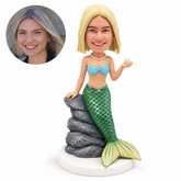 custom bobblehead figure mermaid with a green tail leaning on a rock