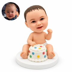 custom bobblehead figure baby in a diaper seated behind a decorated birthday cake