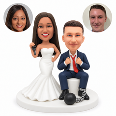 custom bobblehead figures standing bride beside a seated groom with a ball and chain around one ankle
