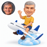 Waving traveler seated astride a miniature passenger airplane on a blue-and-white sculpted cloud base.