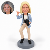 custom bobblehead figure female photographer making a shaka hand gesture while holding a neck-strap camera