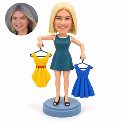 custom bobblehead figure female fashion designer holding two dresses on hangers