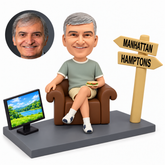 custom bobblehead figure male in an armchair holding a sandwich beside a television and signpost
