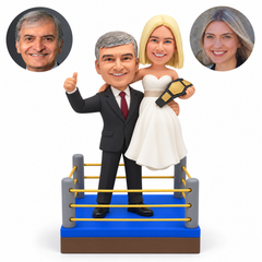 custom bobblehead figures wedding couple in a boxing ring with the groom lifting the bride holding a championship belt