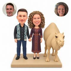 custom bobblehead figures couple holding hands beside a camel