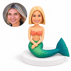 custom bobblehead figure seated mermaid with hands overlapped on her lap and a tail curved to one side
