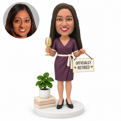 custom bobblehead figure retired woman in a wrap dress holding a glass and hanging sign beside books and a plant