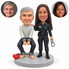 custom bobblehead figures policewoman beside a crouching handcuffed man with ankle chains and a heart-shaped weight