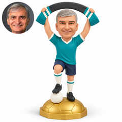 custom bobblehead figure male soccer fan raising a scarf with one foot on a ball atop a golden football pedestal