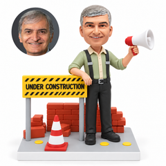 custom bobblehead figure construction worker raising a megaphone beside an under construction sign brick wall and traffic cone
