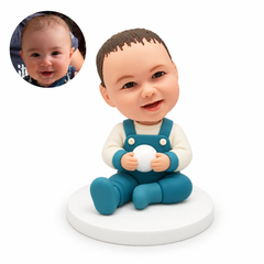 custom bobblehead figure baby seated on the floor holding a small round ball with both hands