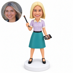custom bobblehead figure female makeup artist raising a brush in her right hand and holding a four-pan palette down at her left side