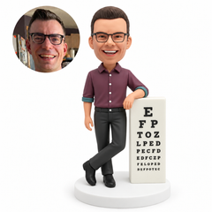 custom bobblehead figure male eye doctor resting his left forearm on a tall eye chart column with his right arm lowered and crossed ankles