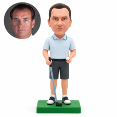 Custom male golfer bobblehead holding one grounded golf club and a golf ball in his opposite hand