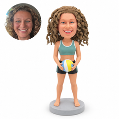 custom bobblehead figure female beach volleyball player standing barefoot and holding a volleyball with both hands at her waist