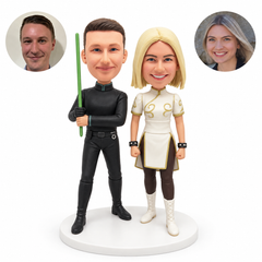 Custom clay fantasy couple bobbleheads: man holding an upright green staff, woman in an ivory short tunic, with matching portrait photos