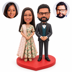 Indian wedding couple clay bobbleheads standing separately, each clasping their own hands on a heart base, with two matching real portrait circles
