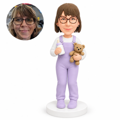 custom bobblehead figure woman in overalls holding a bottle and teddy bear