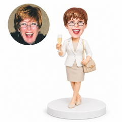 custom bobblehead figure woman in a skirt suit holding a champagne flute and shoulder bag