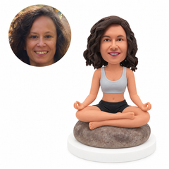 custom bobblehead figure woman meditating cross-legged on a rounded rock seat
