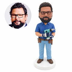 custom bobblehead figure handyman in a blue short-sleeve shirt holding a drill with gloved hands