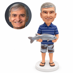 custom bobblehead figure fisherman in a striped polo and shorts supporting a fish horizontally