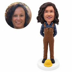 custom bobblehead figure female worker in bib overalls with her hands behind her back and a hard hat on the base