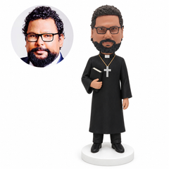 custom bobblehead figure priest in a long robe carrying a closed Bible under one arm