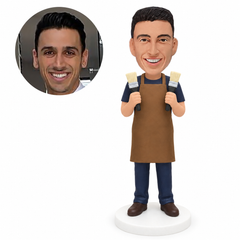 custom bobblehead figure painter in an apron holding two paintbrushes