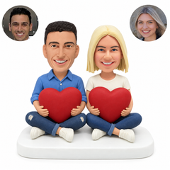 custom bobblehead figures couple sitting cross legged each holding a heart