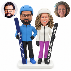 custom bobblehead figures ski couple in helmets each holding one upright ski