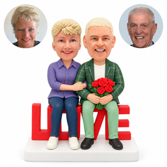 custom bobblehead figures couple sitting on a LOVE shaped seat with flowers