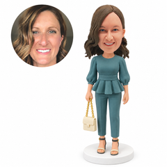 custom bobblehead figure woman in a peplum top and ankle trousers carrying a chain handbag