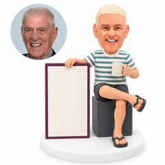 custom bobblehead figure older man seated on a cube with a mug and a large sign