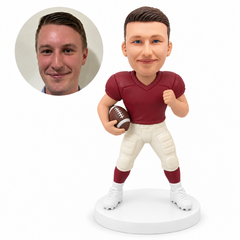custom bobblehead figure male football player holding ball with raised fist and grounded stance; original Bobblefigurine sculpted clay head and matching human portrait.