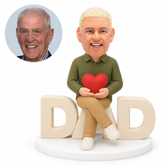 custom bobblehead figure man seated on DAD letters holding a heart