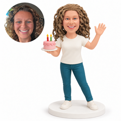 custom bobblehead figure woman holding a birthday cake while raising her other hand to wave