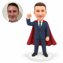 custom bobblehead figure businessman in a suit and cape raising one fist with his other arm down
