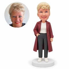 custom bobblehead figure older woman in a trench coat with one hand in a trouser pocket MGA-AC1271
