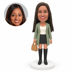 custom bobblehead figure woman in a long cardigan and mini skirt with tall boots holding a handbag at her side