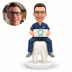 custom bobblehead figure male dentist sitting on a giant tooth and holding a sign