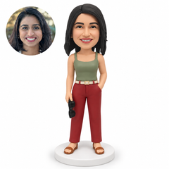 custom bobblehead figure woman holding sunglasses low beside her right thigh with her left hand in her trouser pocket