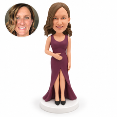 custom bobblehead figure woman in a floor-length slit gown with her right hand across her abdomen and her left arm lowered