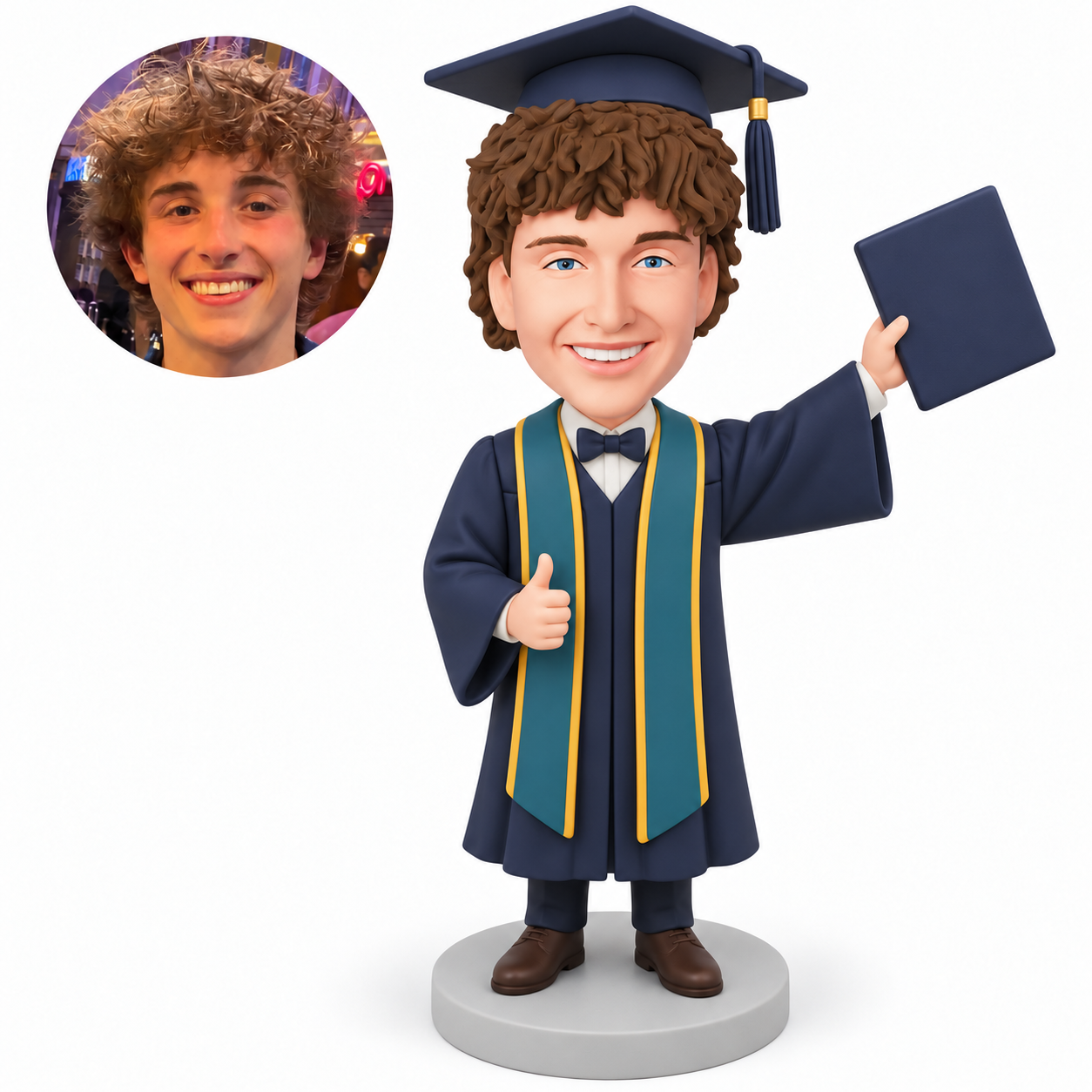 Custom polymer-clay male graduate giving a right thumbs-up and raising one closed certificate folder in his left hand, wearing a navy gown and teal stole on a plain round base, with matching real portrait