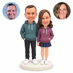 Custom clay couple with his right hand in a trouser pocket, her left hand in a hoodie pouch and her right empty hand lowered, with paired photo references