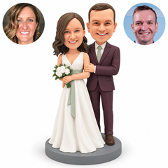 Custom clay wedding couple: bride holding one white bouquet with both hands, groom with left hand on her left upper arm, original clay heads and paired real-photo circles. MGA-AC1795.
