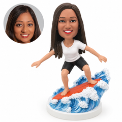 custom bobblehead figure woman surfing on a board over sculpted waves