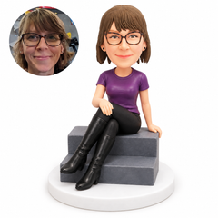 custom bobblehead figure woman in a T-shirt and trousers seated on stone steps